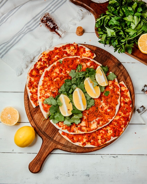 Photo gratuite lahmajun avec de la viande une tranche de citron sur une planche ronde _