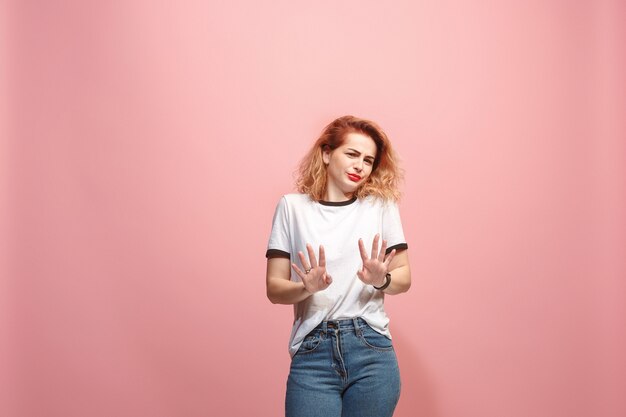 Laisse-moi penser. Femme pensive douteuse avec une expression réfléchie faisant un choix contre le mur rose