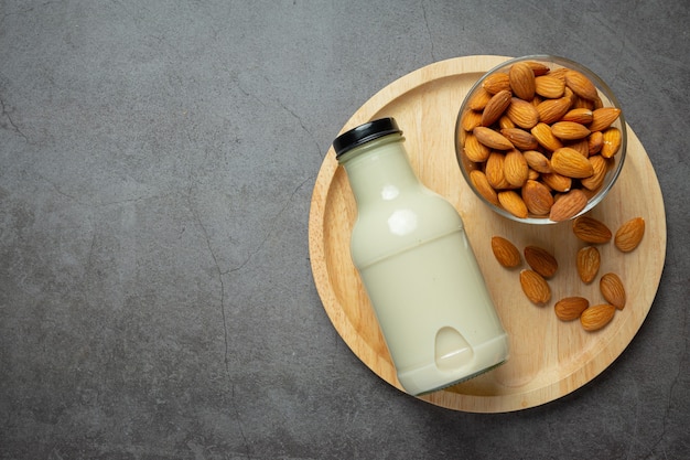 Lait d'amande en bouteille aux amandes sur fond sombre