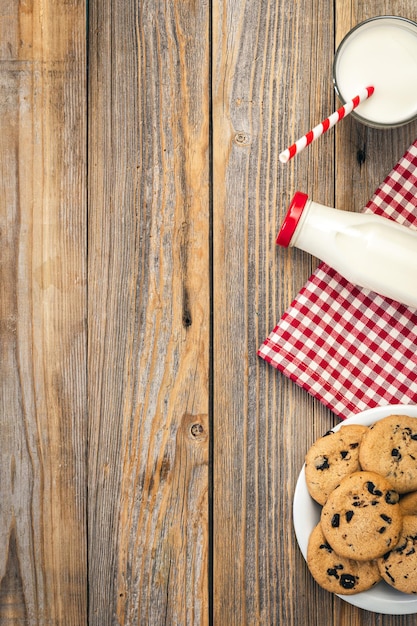 Photo gratuite lait et biscuits au chocolat sur fond plat en bois