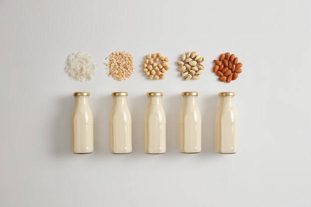 Lait blanc végétal à base de noix de coco, d'avoine, de noisette, de pistache et d'amande. Ingrédients pour préparer une boisson végétarienne. Le produit contient une bonne quantité de protéines, de vitamine D, de calcium. Boisson saine