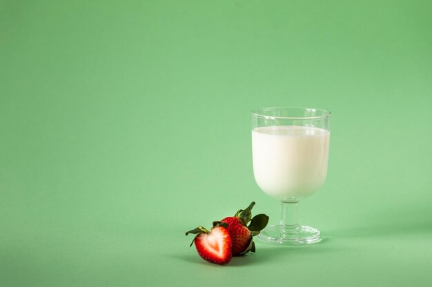 Lait et fraises fraîches sur fond vert alimentation saine et mode de vie nutritionnel