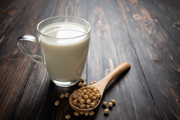 Lait de soja et soja sur table en bois.