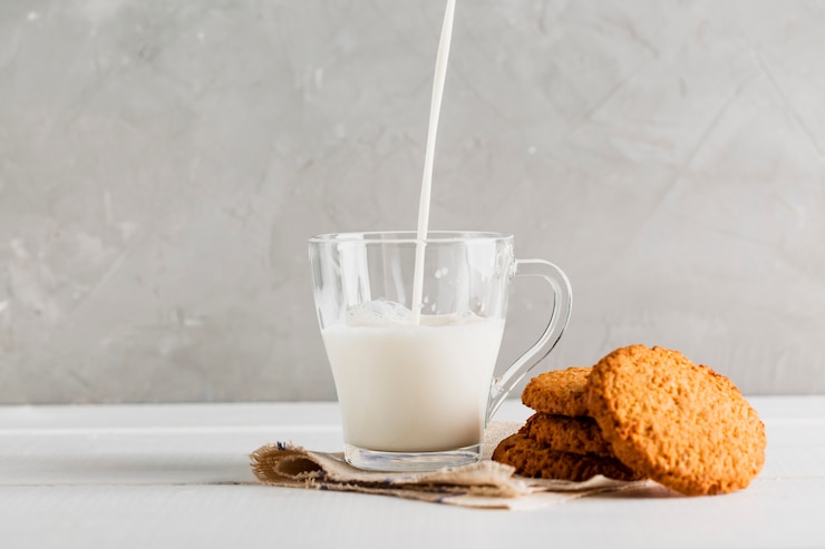 Photo gratuit lait versé dans un verre avec des biscuits