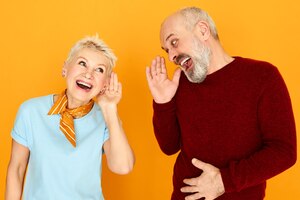 Le langage du corps. portrait de deux retraités caucasiens âgés drôles avec problème d'audition ayant une conversation, gardant les mains à l'oreille et criant, mais ne peut pas distinguer les mots. concept de surdité