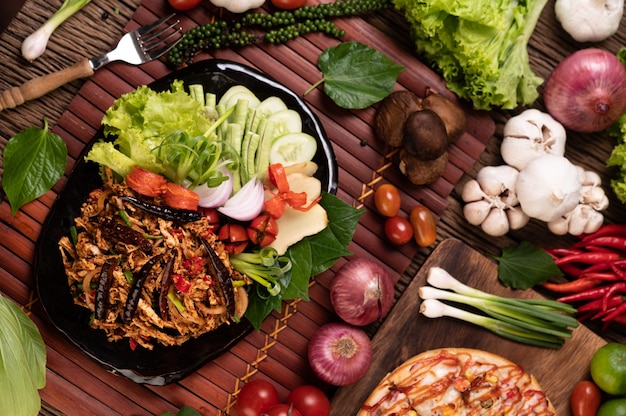 Photo gratuite larb de poulet dans l'assiette avec piments séchés, tomates, oignons nouveaux et laitue