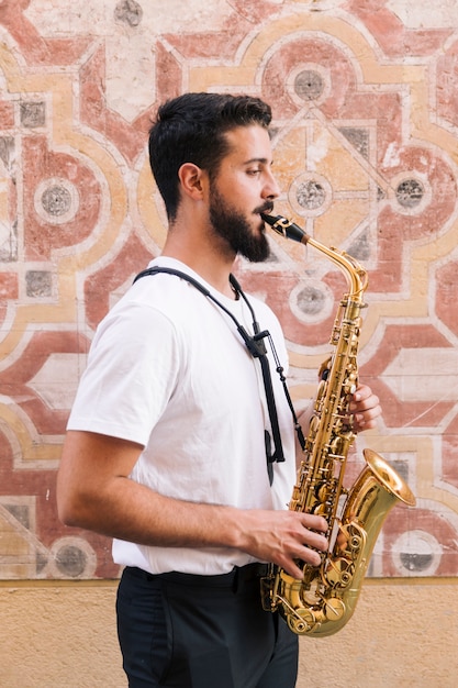 Latéral, homme, coup moyen, jouer, saxophone, à, géométrique, fond