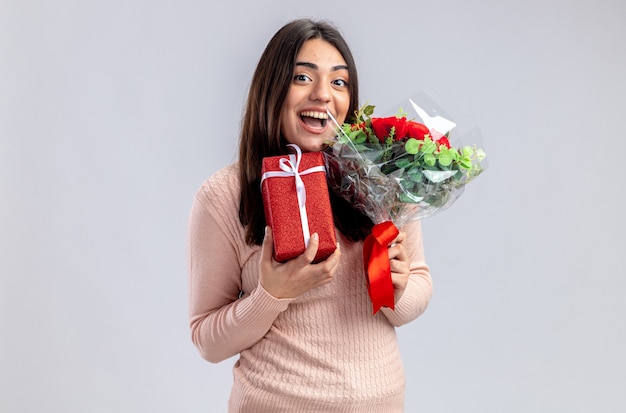 Laughing young girl on valentines day holding gift box avec bouquet isolé sur fond blanc