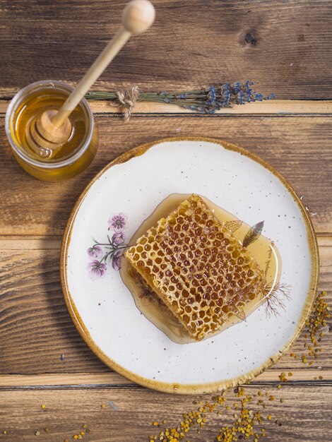 Lavande; pot de miel avec une louche en bois et des pollens d&#39;abeilles sur une table en bois