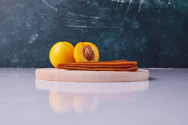 Lavash de fruits du Caucase avec des pêches jaunes dans une assiette blanche sur fond bleu. Photo de haute qualité