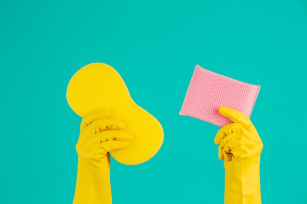 Photo gratuite lave-vaisselle portant des gants jaunes sur un bleu.