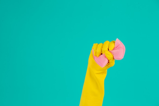 Photo gratuite lave-vaisselle portant des gants jaunes sur un bleu.