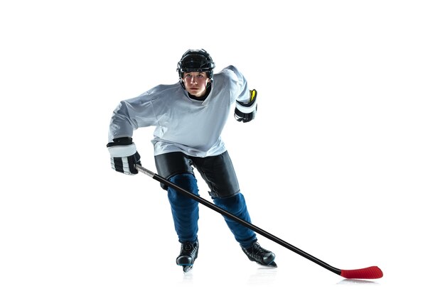 Leader. Jeune joueur de hockey masculin avec le bâton sur le court de glace et fond blanc. Sportif portant de l'équipement et un casque pratiquant. Concept de sport, mode de vie sain, mouvement, mouvement, action.