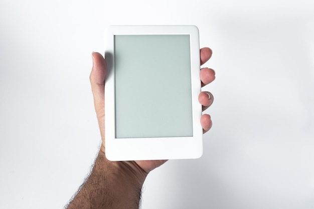 Lecteur d'ebook sur fond blanc isolé tenu par une main masculine