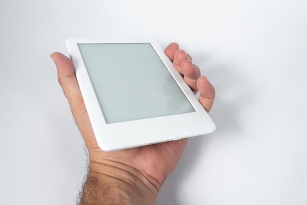 Photo gratuite lecteur d'ebook sur fond blanc isolé tenu par une main masculine