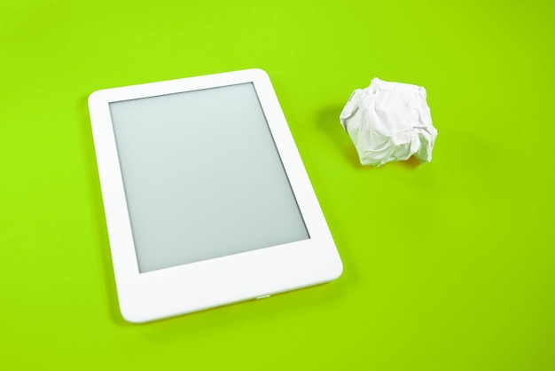 Lecteur d'ebook sur fond jaune avec boule de papier à côté