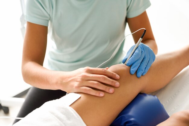 Électroacupuncture sèche avec une aiguille sur un genou femelle