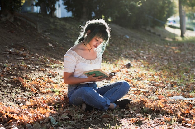 Lecture de fille sur une colline ensoleillée