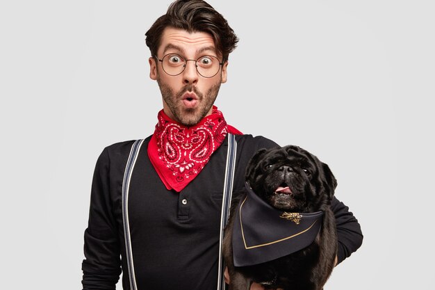 Élégant homme brunet portant un bandana rouge tenant un chien