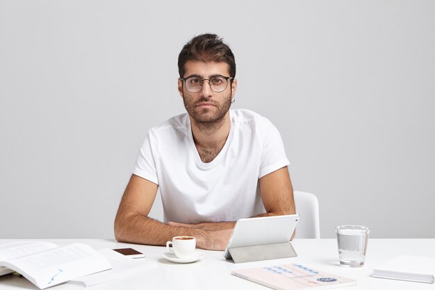 Élégant jeune homme assis au bureau