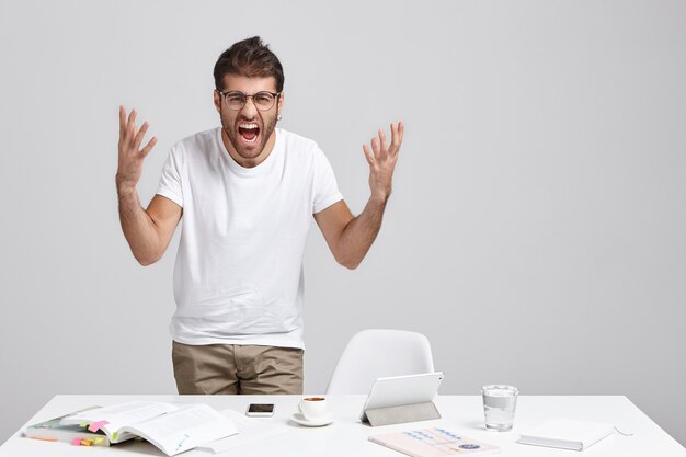 Élégant jeune homme debout près du bureau