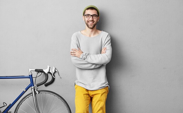 Élégant jeune homme debout près de vélo