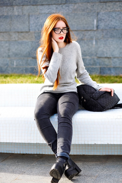 Élégant portrait automne hiver en plein air de jolie adolescente au gingembre, tenue décontractée élégante et sac à dos, lunettes de soleil claires