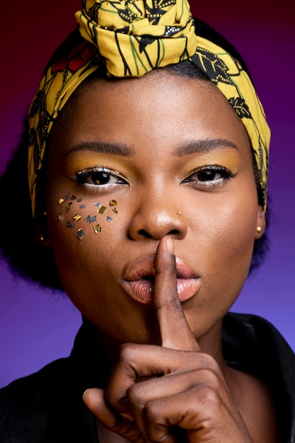 Élégante femme africaine faisant le signe du silence