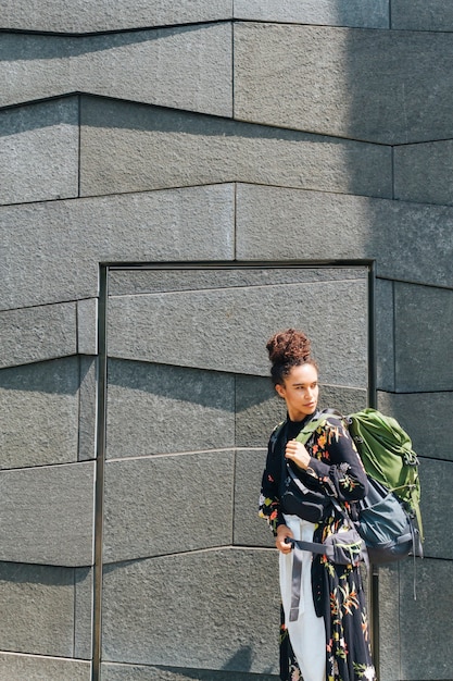 Élégante femme portant un sac à dos à la recherche de l'extérieur