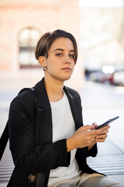 Élégante femme tenant son téléphone