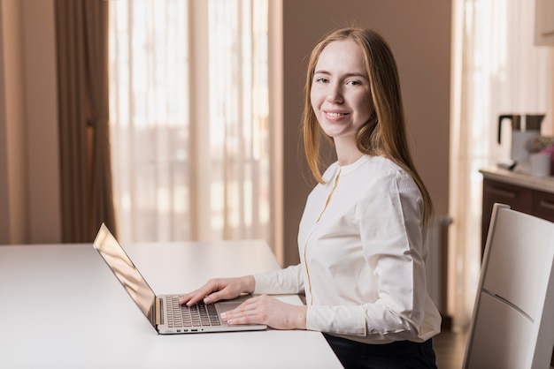 Élégante fille heureuse avec un ordinateur portable