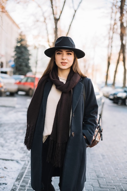 Élégante, jeune femme, bonnet, manteau, à, écharpe, rue