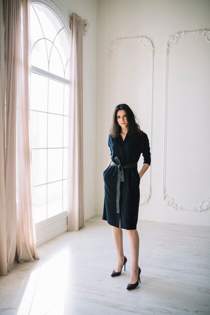 Élégante jeune femme en robe dans la chambre