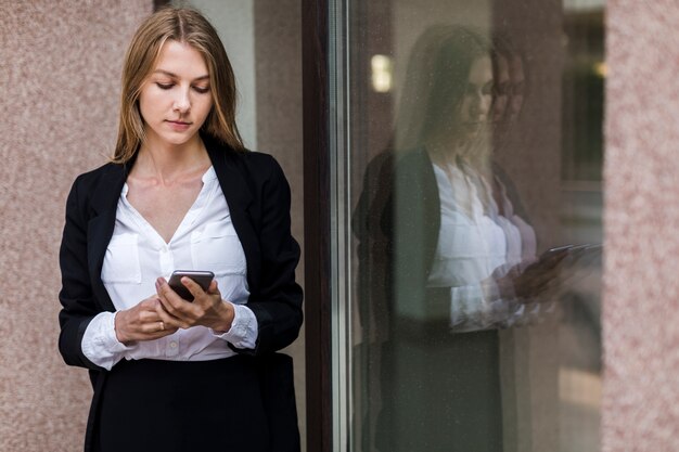 Élégante jeune femme utilisant son téléphone