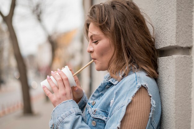 Élégante jeune fille buvant du soda