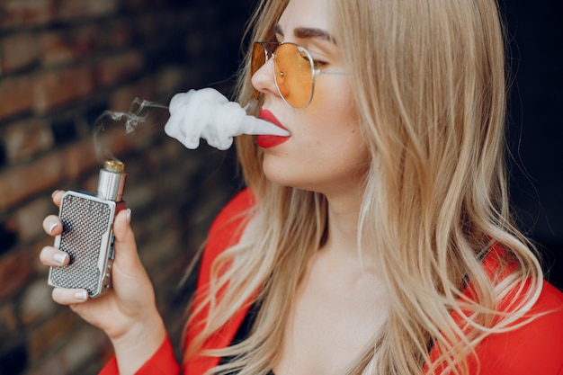 Élégante jeune fille dans une ville avec vape