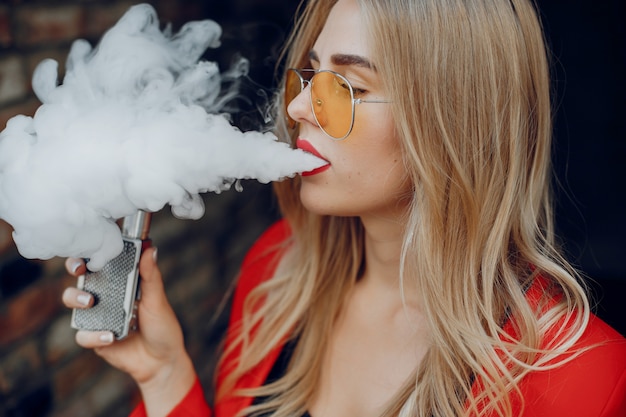 Élégante jeune fille dans une ville avec vape