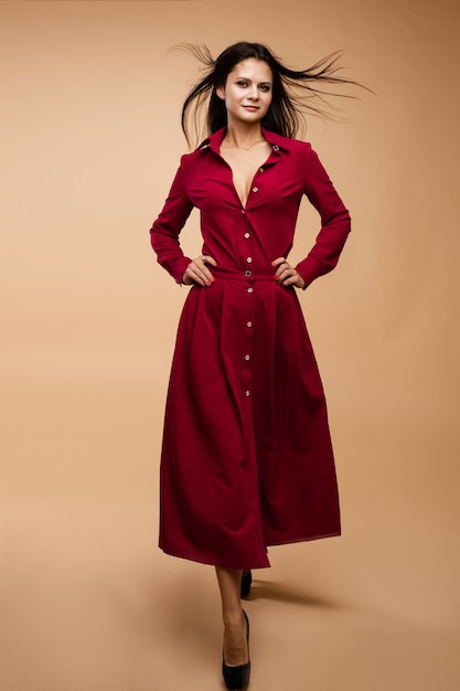 Élégante jeune mannequin brune en robe rouge