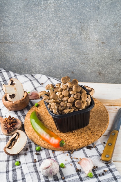 Légume; épices; liège coaster et couteau sur table en bois