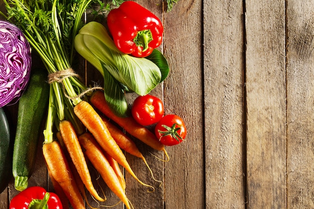 Légumes alimentaires fond coloré. Savoureux légumes frais sur une table en bois. Vue de dessus avec espace de copie.