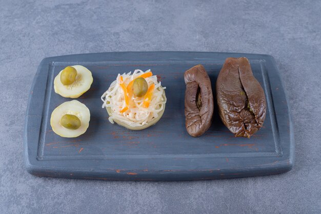 Légumes en conserve. Choucroute et aubergines fourrées sur planche de bois.