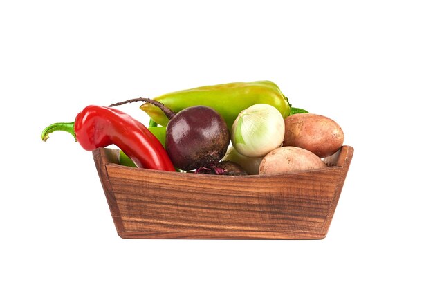 Légumes dans un plateau en bois sur blanc.