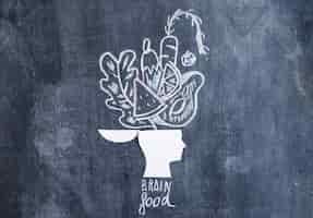 Photo gratuite légumes dessinés sur la tête ouverte sur le tableau noir