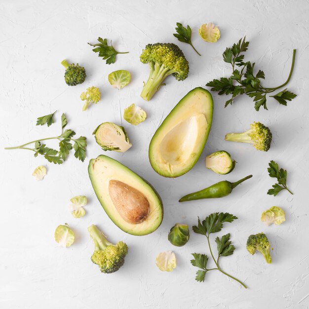 Légumes sur fond blanc avec avocat au centre