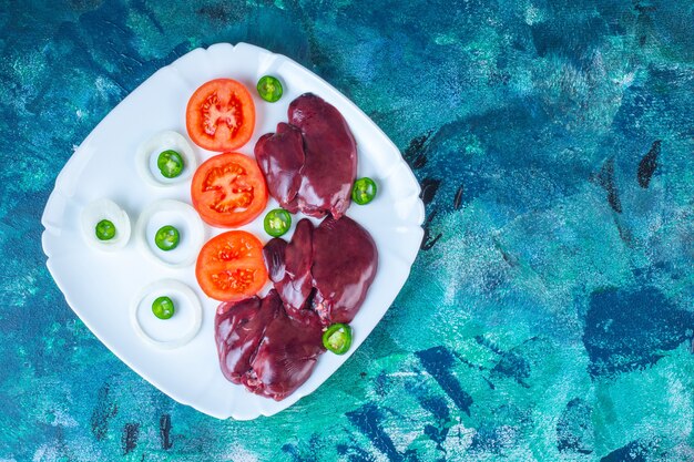 Légumes frais et foies de poulet dans une assiette