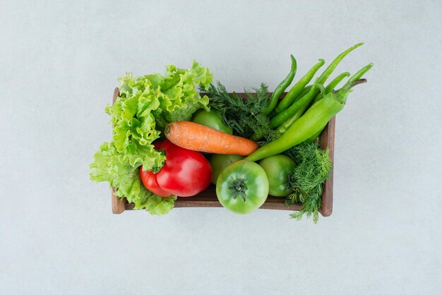 Légumes frais mélangés dans une boîte en bois.