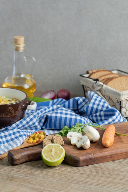 Légumes frais, pain, huile et nouilles sur table en bois