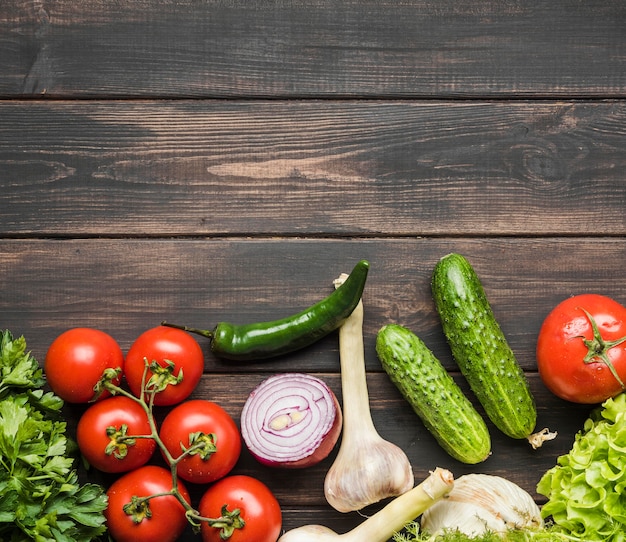 Légumes frais pour salade sur fond de bois