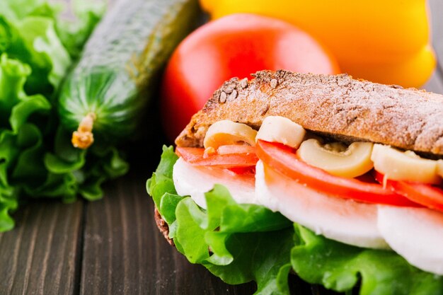 Les légumes frais, la salade, les œufs et les champignons se trouvent entre des morceaux de pain entier et croustillant