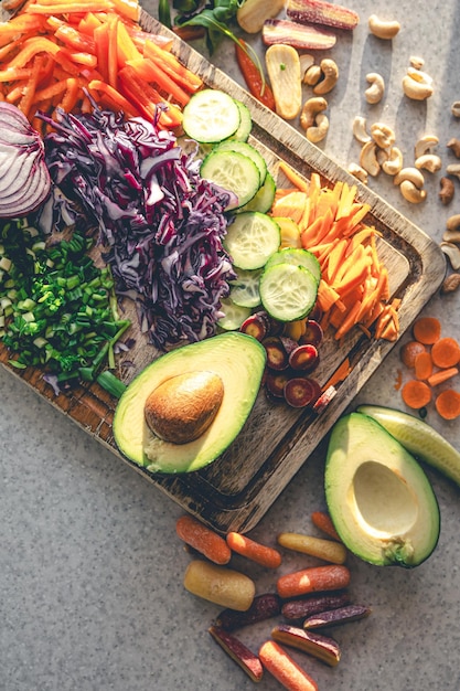 Photo gratuite des légumes frais tranchés sur une planche à couper sur la table de la cuisine